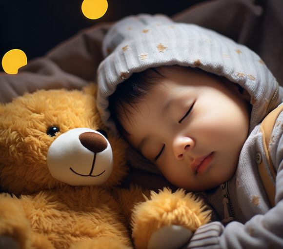 a child sleeping soundly next to a teddy bear