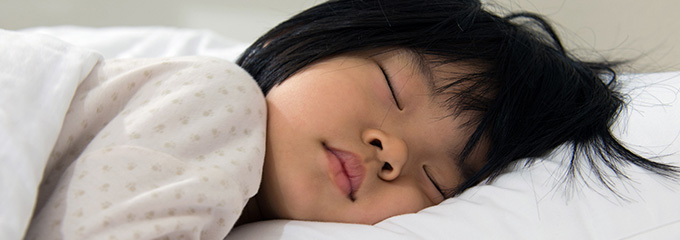 a young girl asleep on a bed 